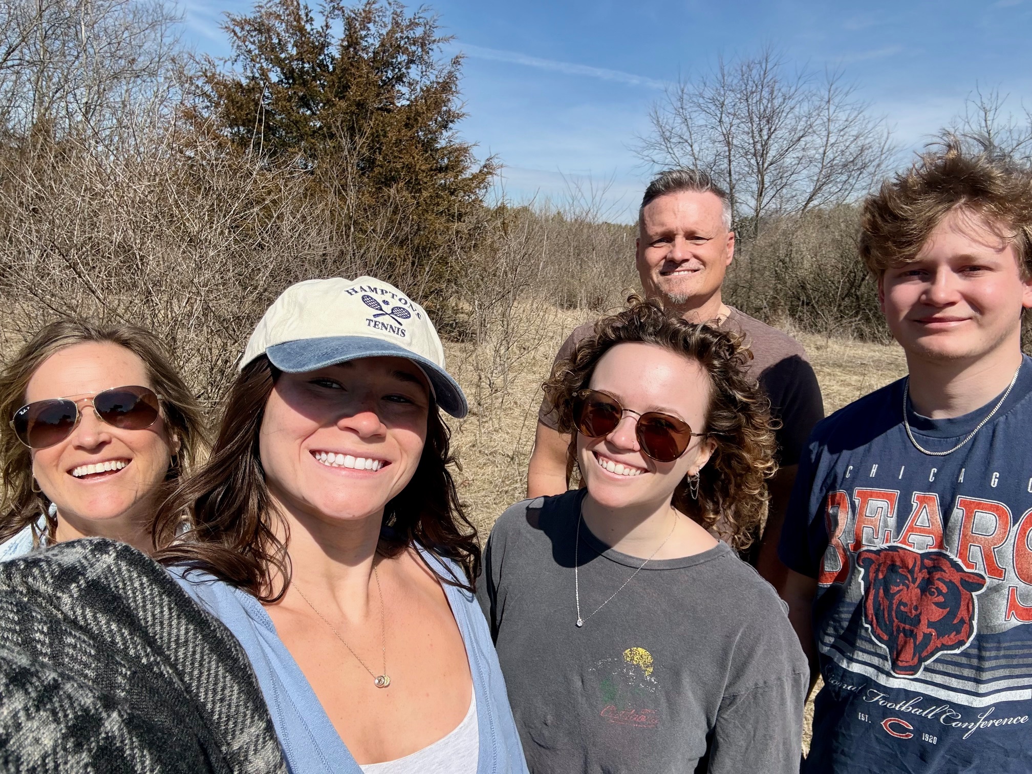 family posing on land where they will build a house