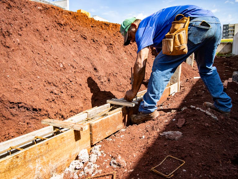 Male construction worker building a foundation.