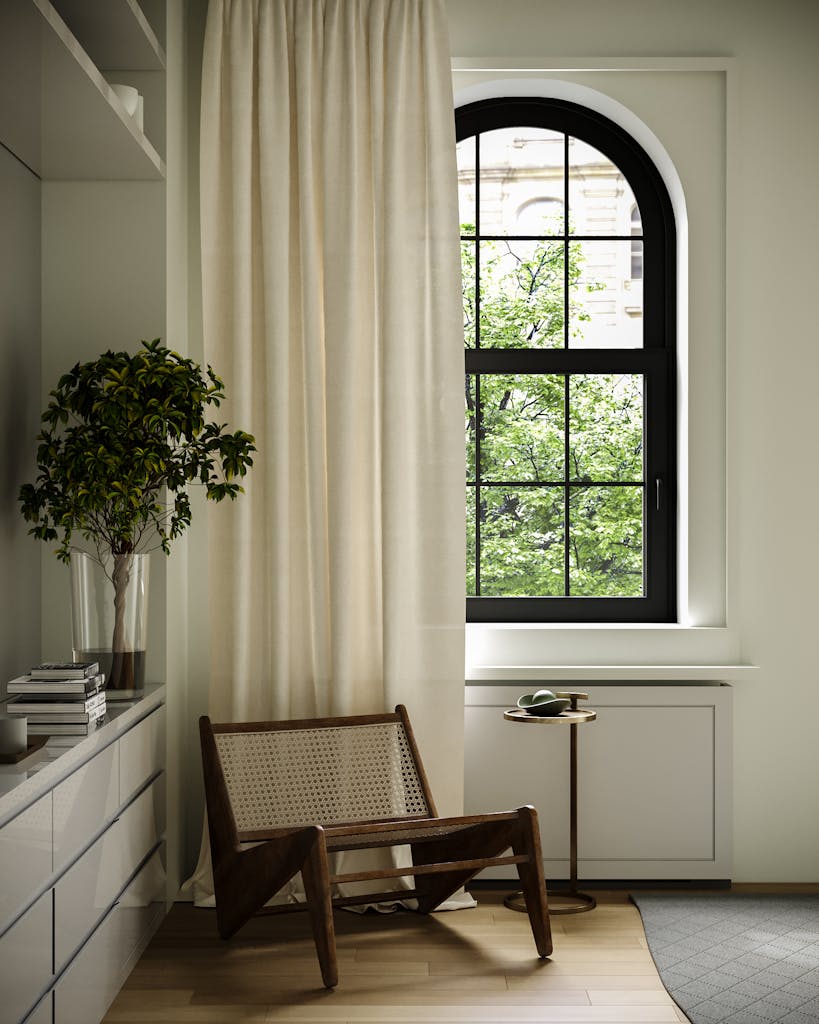 Elegant minimalist room with a wooden chair, potted plant, and arched window providing natural light.