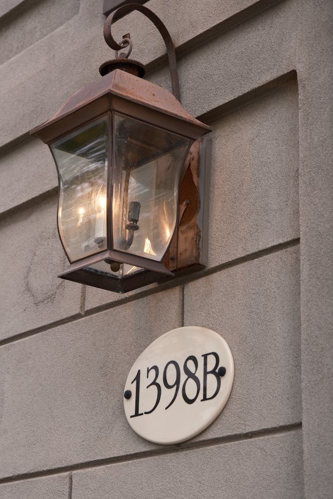 Vintage outdoor lantern and address plaque on a brick wall in Toronto, Canada.