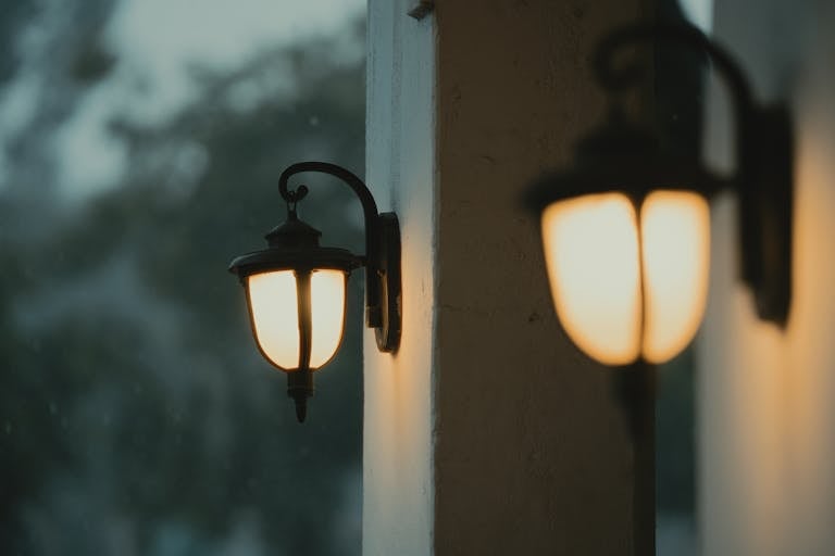 Warm glow of traditional exterior lighting lanterns creates ambiance as evening falls outdoors.