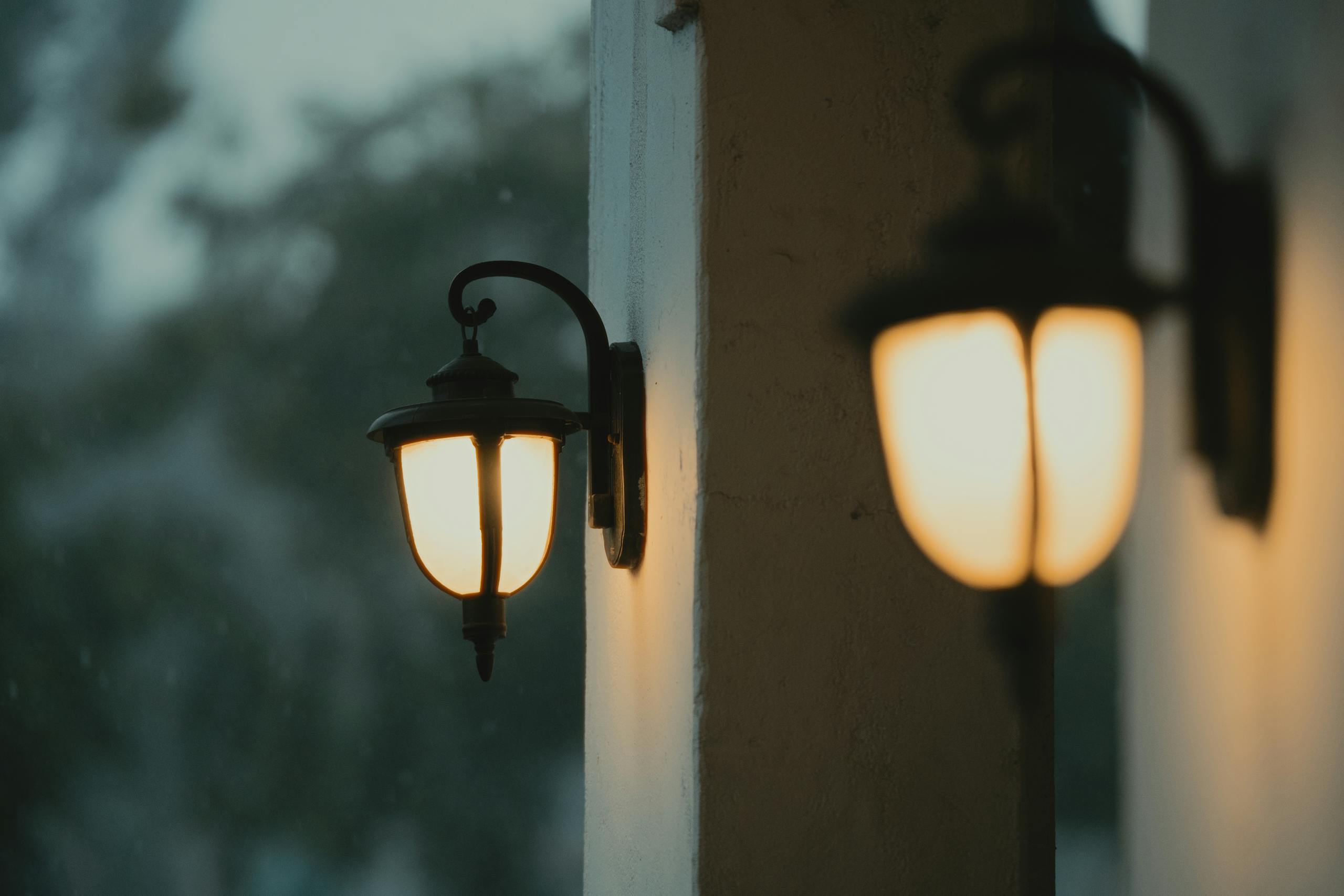 Warm glow of traditional exterior lighting lanterns creates ambiance as evening falls outdoors.