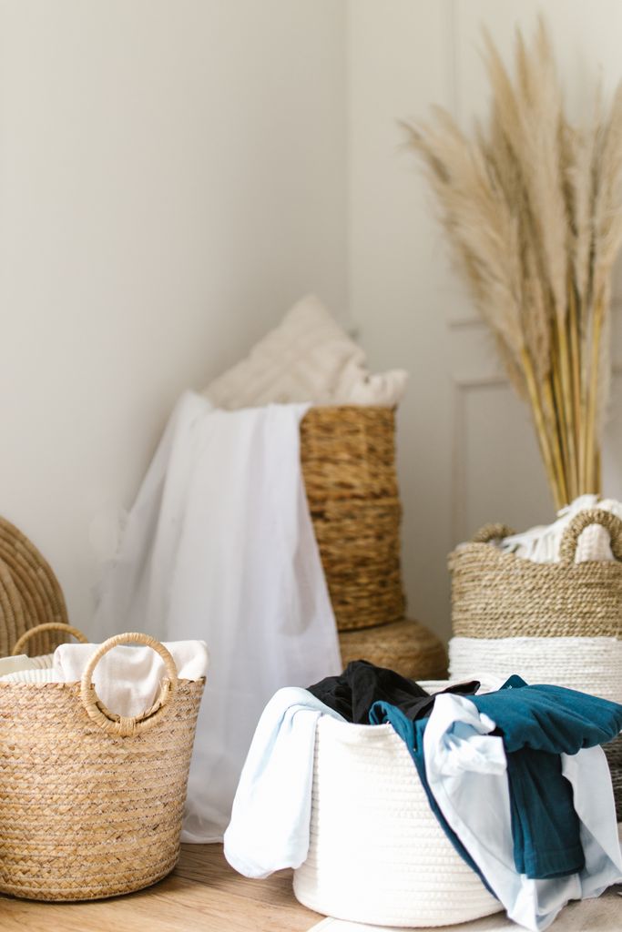 Stylish and cozy laundry room featuring woven baskets and dried pampas grass for decor.