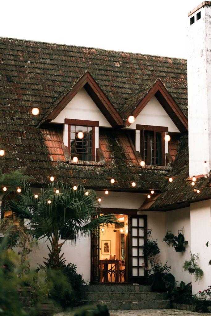 Cozy cottage exterior with string lights and warm ambiance, ideal for peaceful retreats.