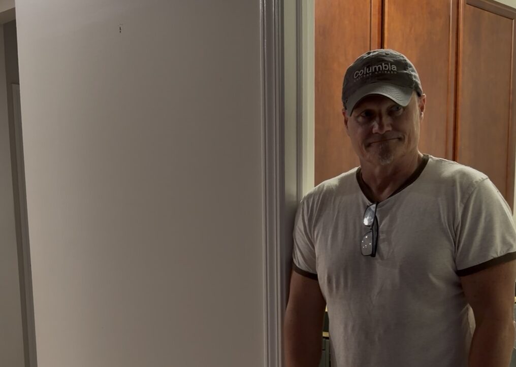 Mike standing in empty doorway of our family home on moving day